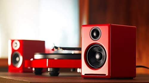 Red speakers and a turntable on a wooden surface providing a great sound experience